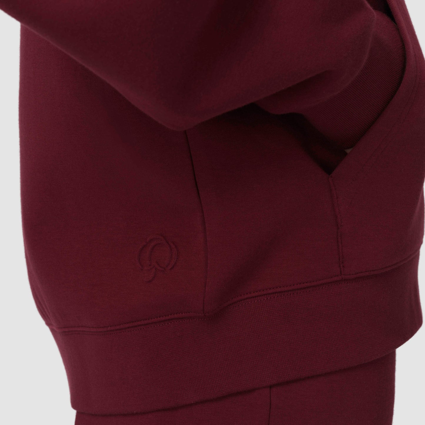 Sweat à capuche bordeaux avec un logo sur fond blanc