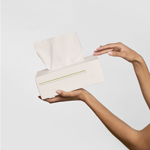 Box of 100% premium cotton tissues for hygiene and care hold by two hands