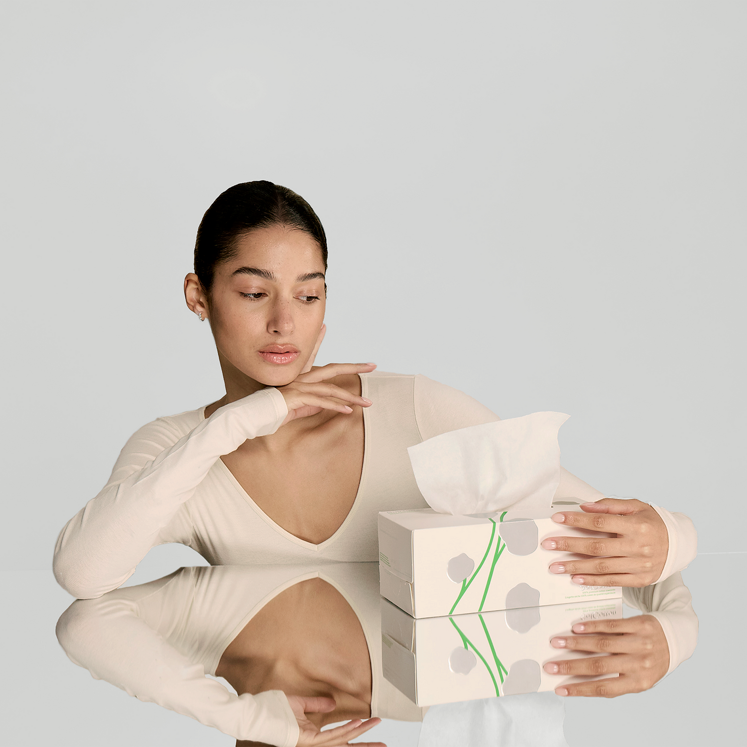 Box of 100% premium cotton towelette skincare routine with delicate model