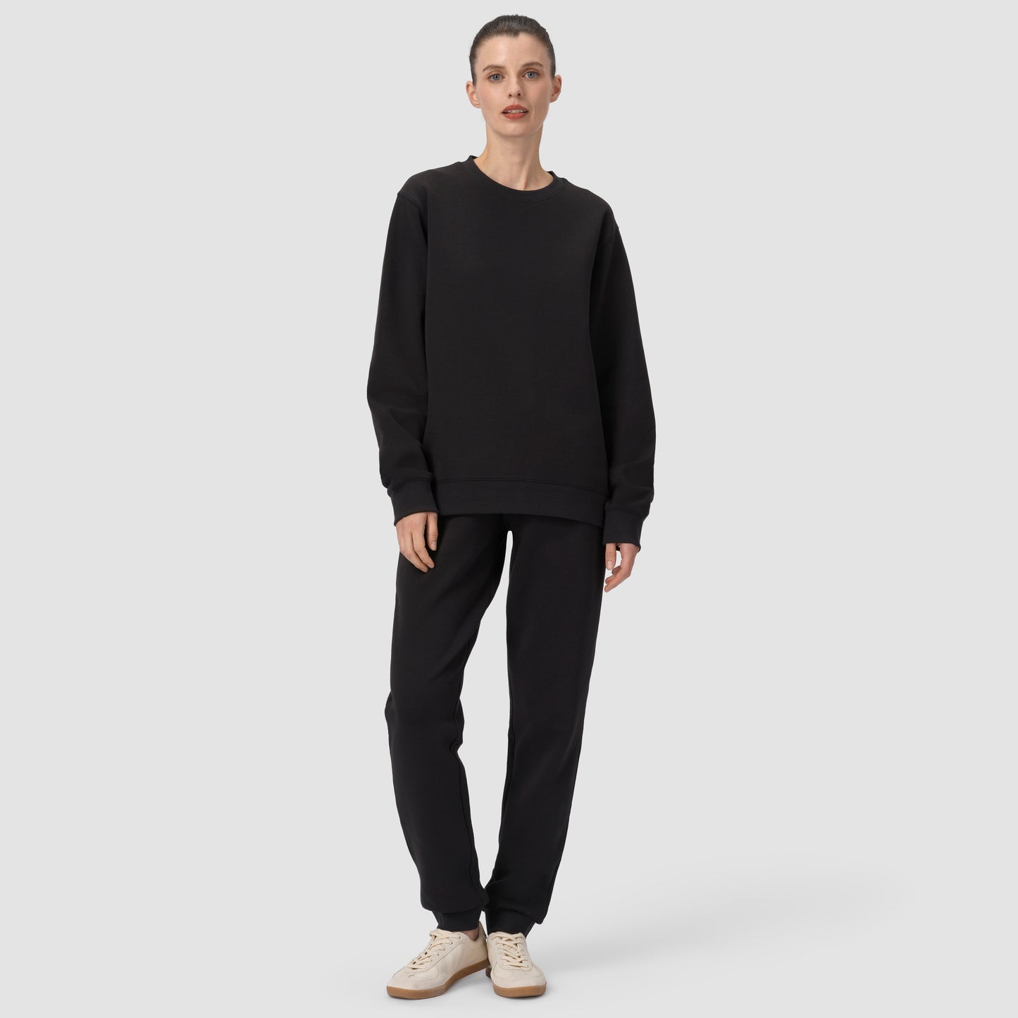 Person wearing a black outfit on a white background