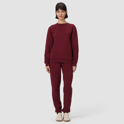 Une personne vêtue d'un sweat-shirt et d'un pantalon bordeaux sur fond blanc