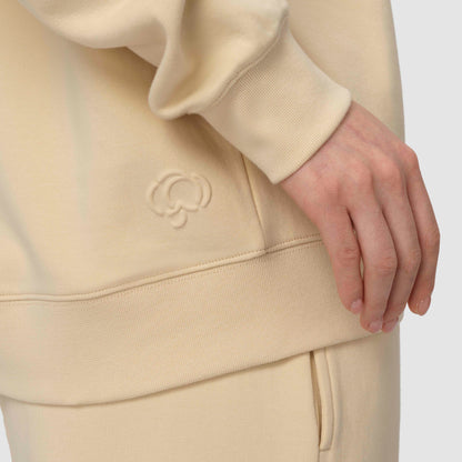Close up of cream cotton hoodie with embossed cotton flower