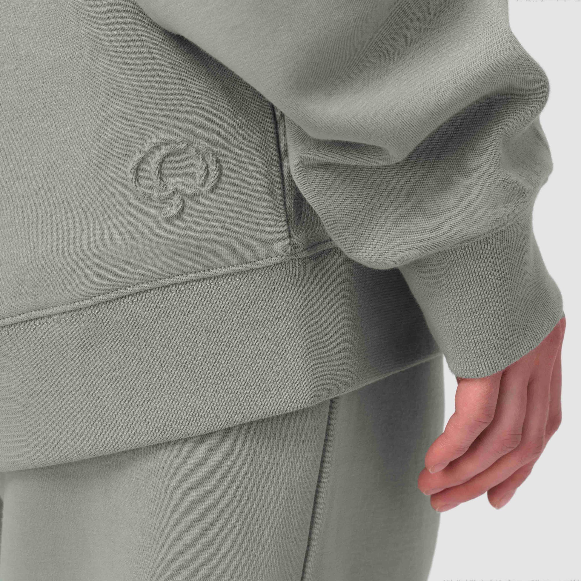 Close up of green sage hoodie with embossed cotton flower detail