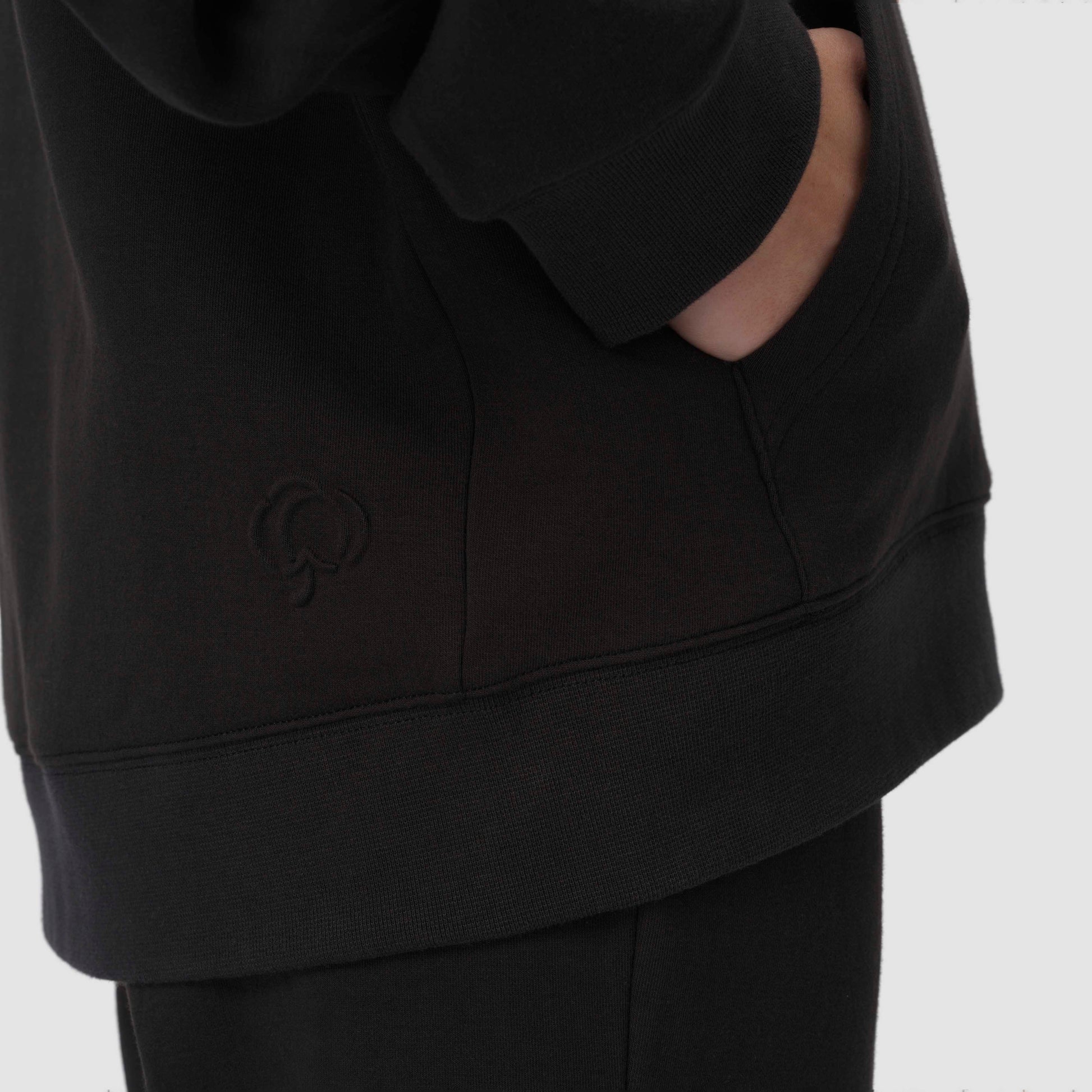 Sweat à capuche noir avec un logo sur fond blanc