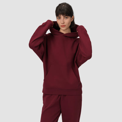 Person wearing a cream hoodie and pants on a plain background