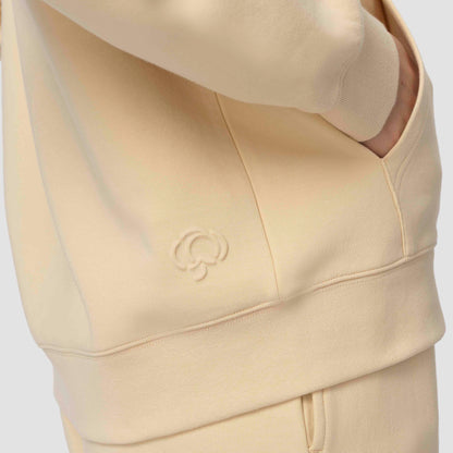 Sweat à capuche crème avec un logo sur fond blanc