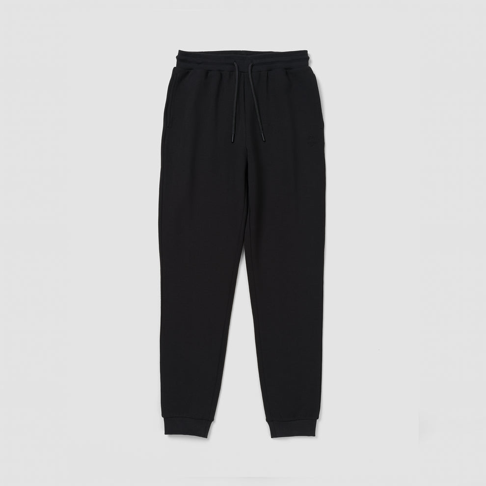 Un pantalon de survêtement noir sur fond gris clair