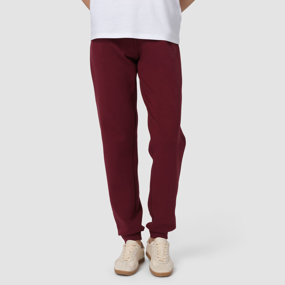 Photo du bas : une personne portant un pantalon de jogging bordeaux, des chaussures blanches et un t-shirt