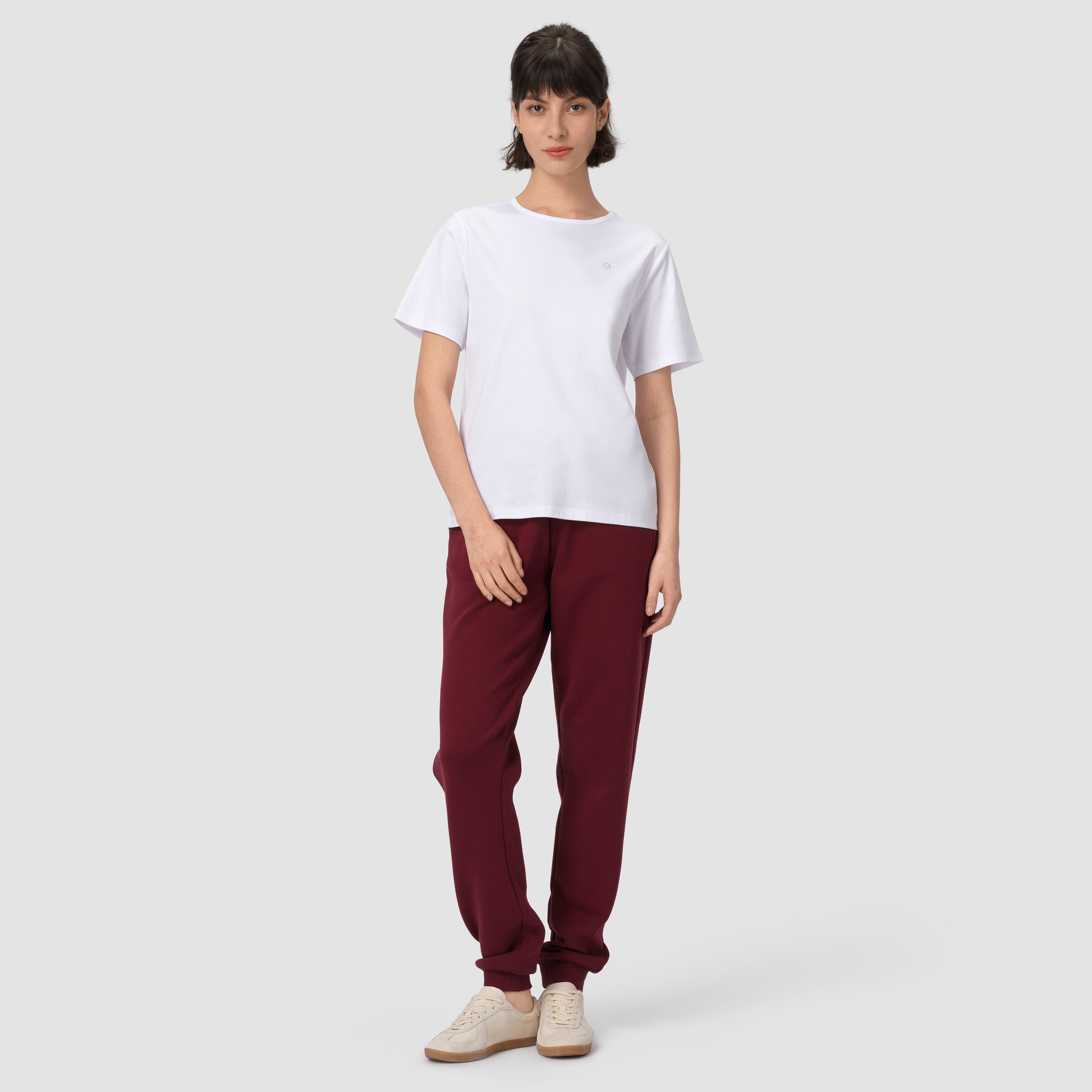 Full feet pic of model wearing burgundy jogging with white tee and shoes