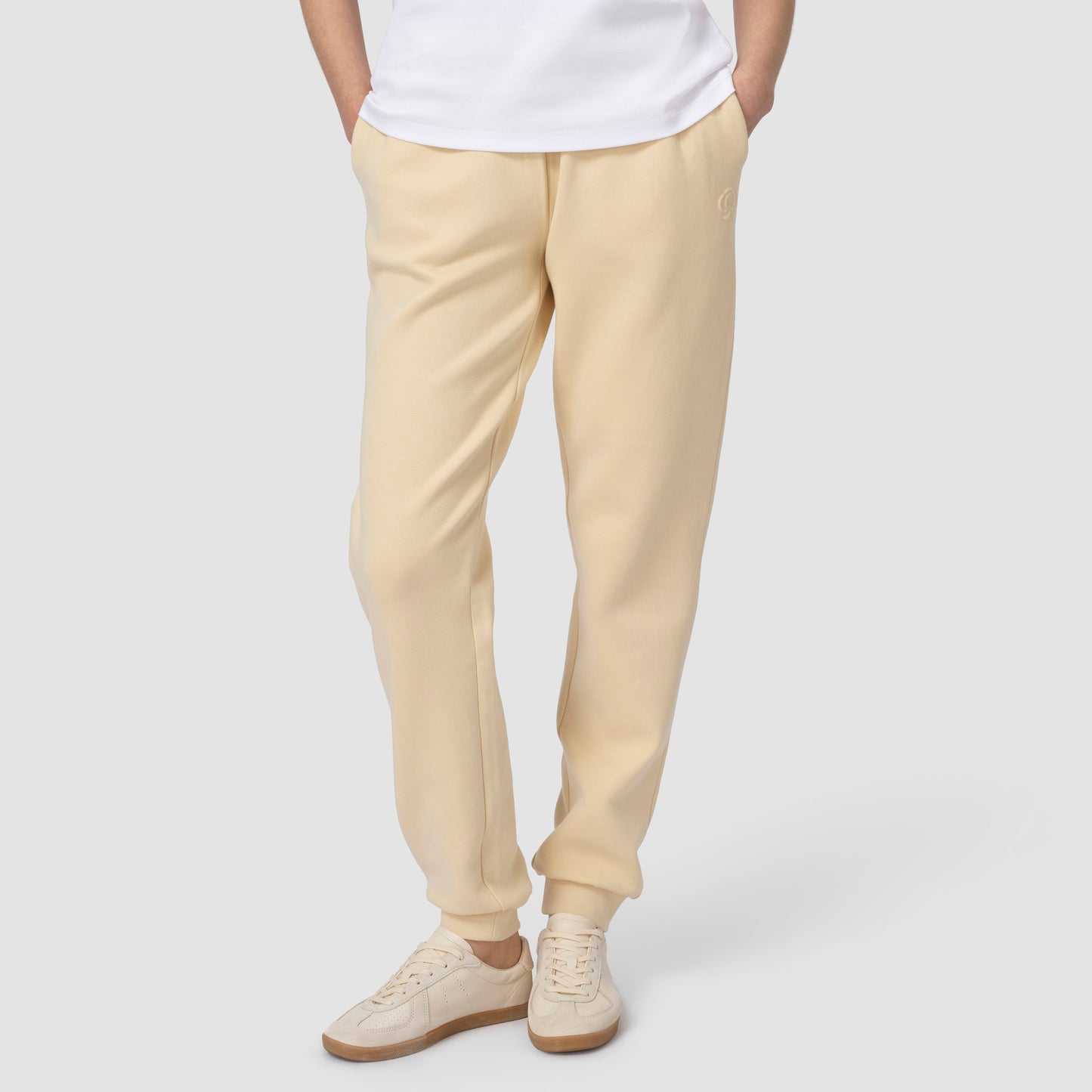 Bottom pic of person wearing cream jogging with white shoes