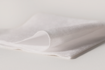 Close-up of white fabric with a subtle texture on a light gray background