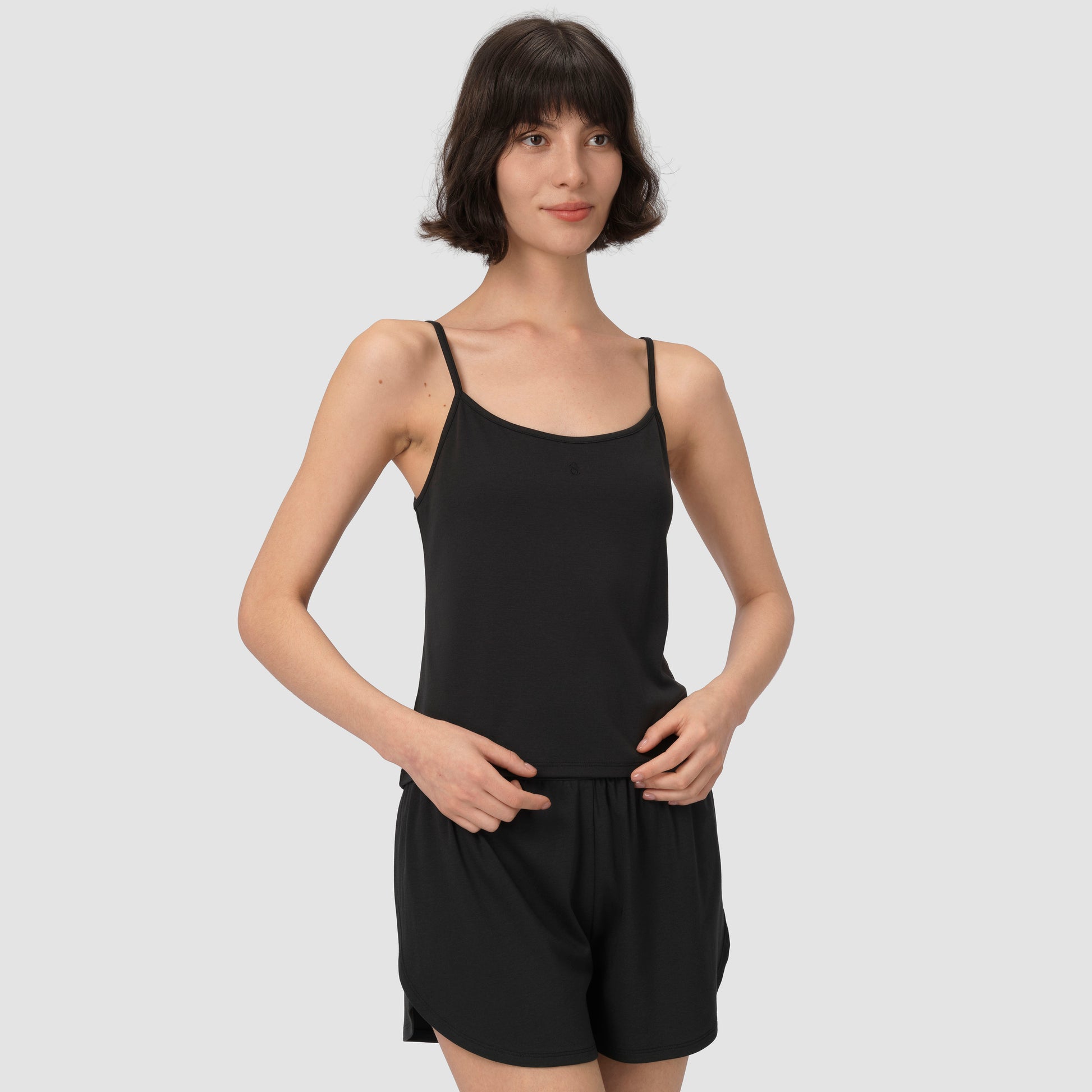 Model smliling with black pajama on plain background