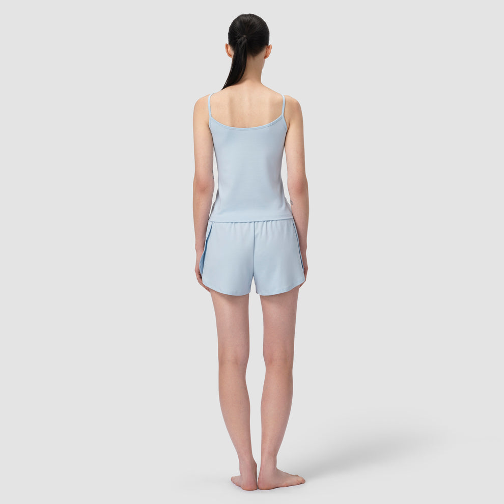 Dos d'un mannequin vêtu d'un pyjama court bleu clair sur fond uni