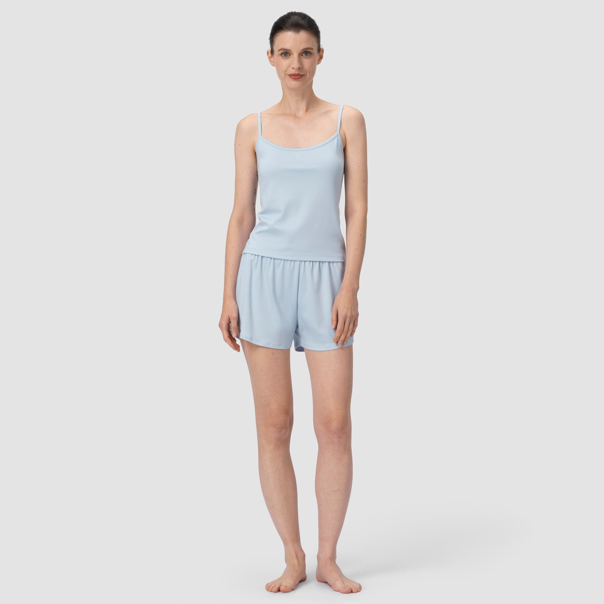 Model in full feet wearing light blue pajama in plain background