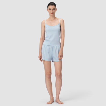 Model in full feet wearing light blue pajama in plain background