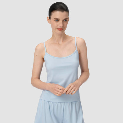 Model smiling wearing a light blue pajama in a plain backround