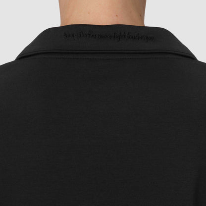 Back close up of black pajamas with the sentence Sleep like the moonlight touches you