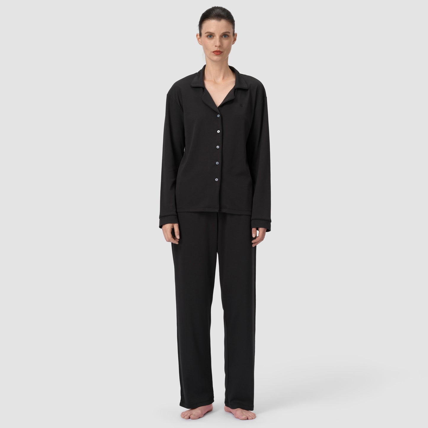 Woman wearing a black pajama set on a white background