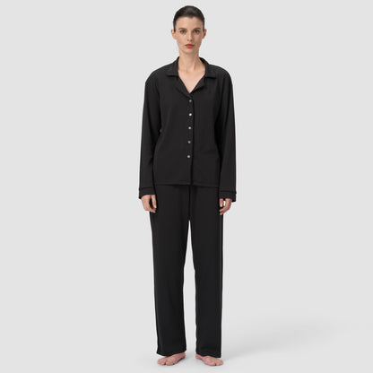 Woman wearing a black pajama set on a white background