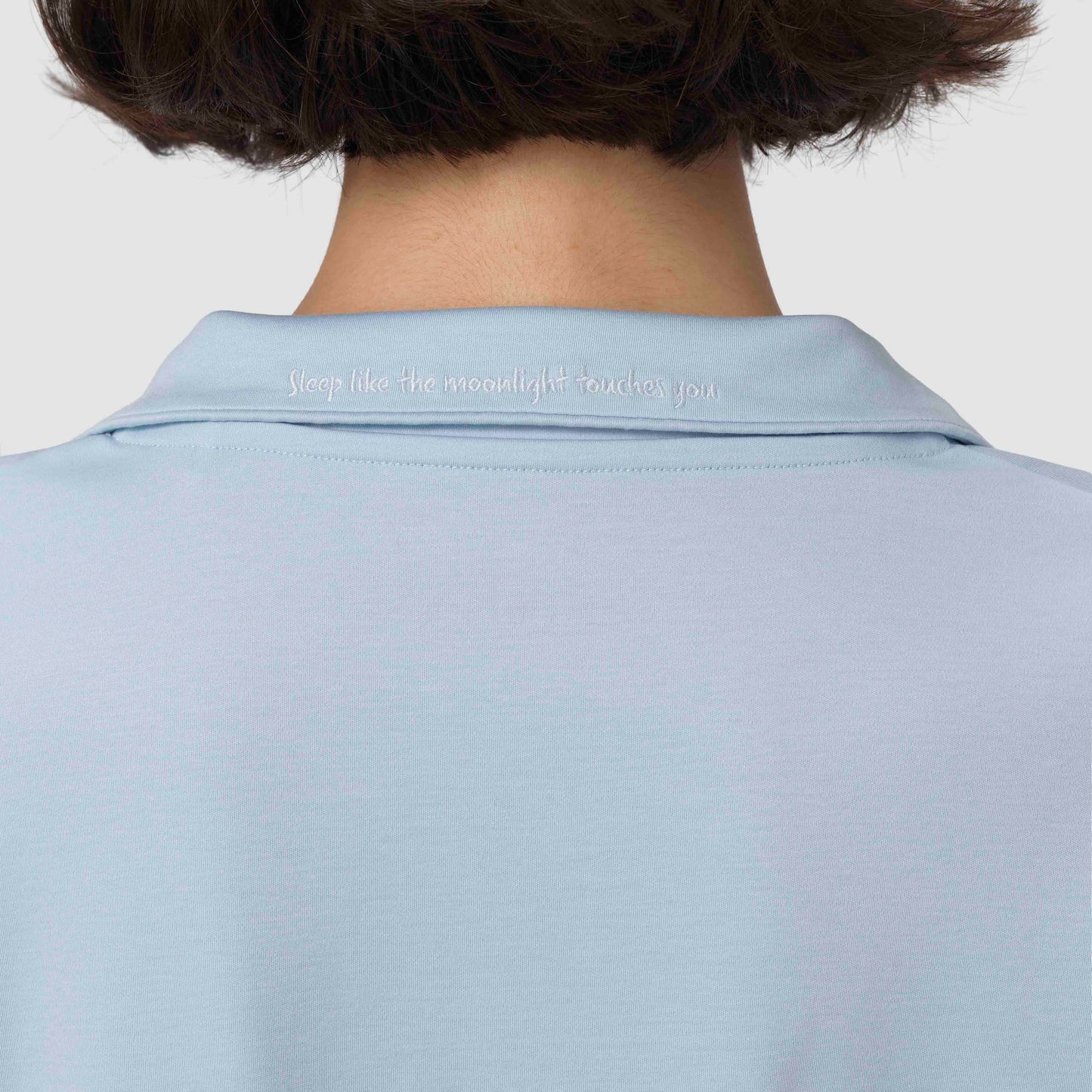 Light blue pajama with text on the collar against a plain background