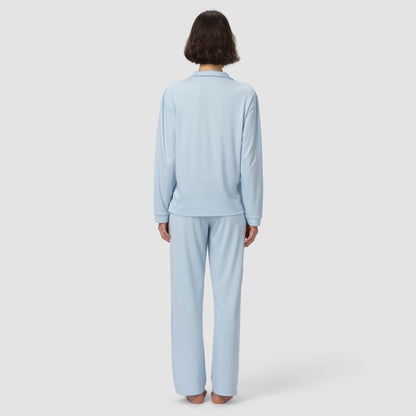 Person wearing a light blue pajama set on a white background
