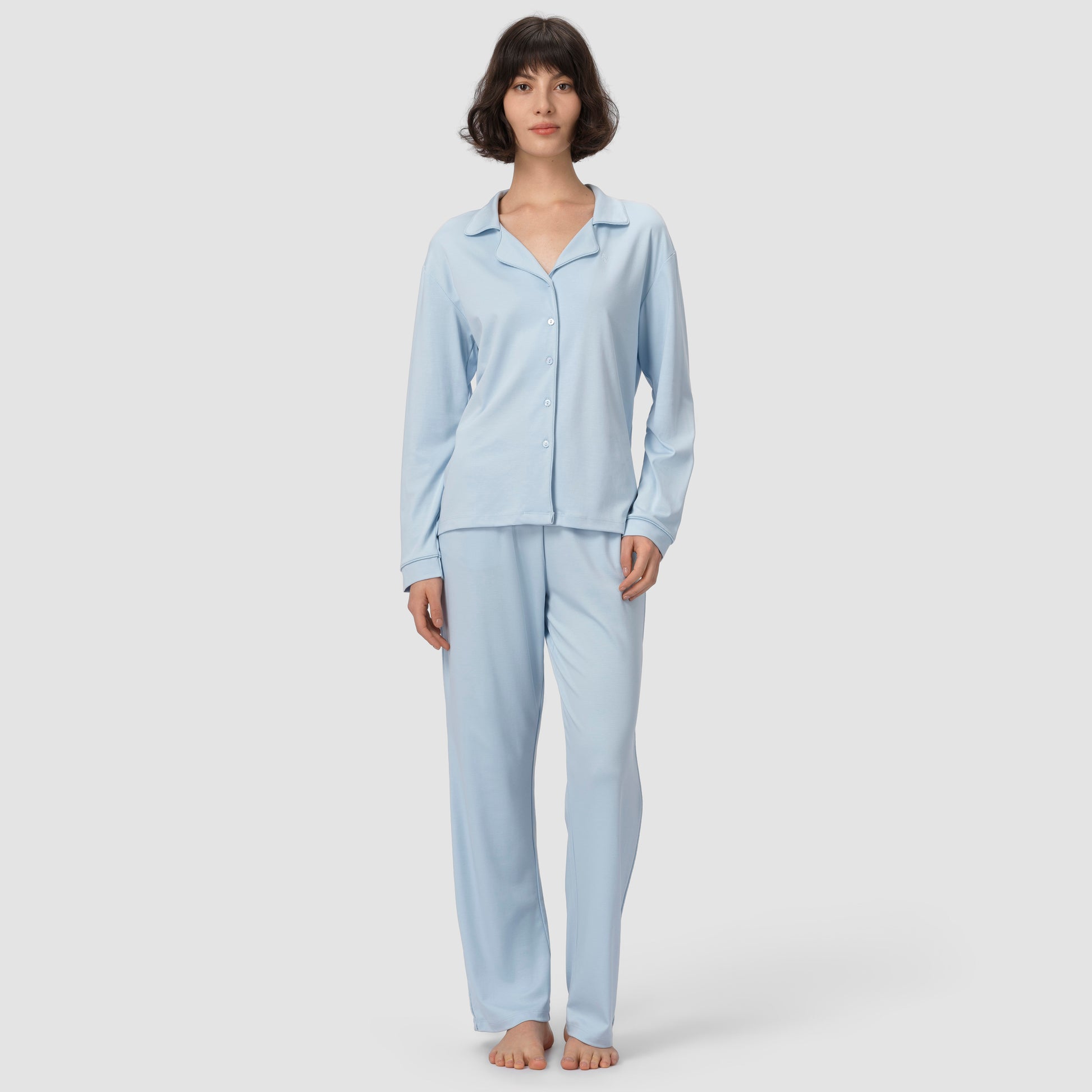 Woman wearing light blue pajamas on a white background