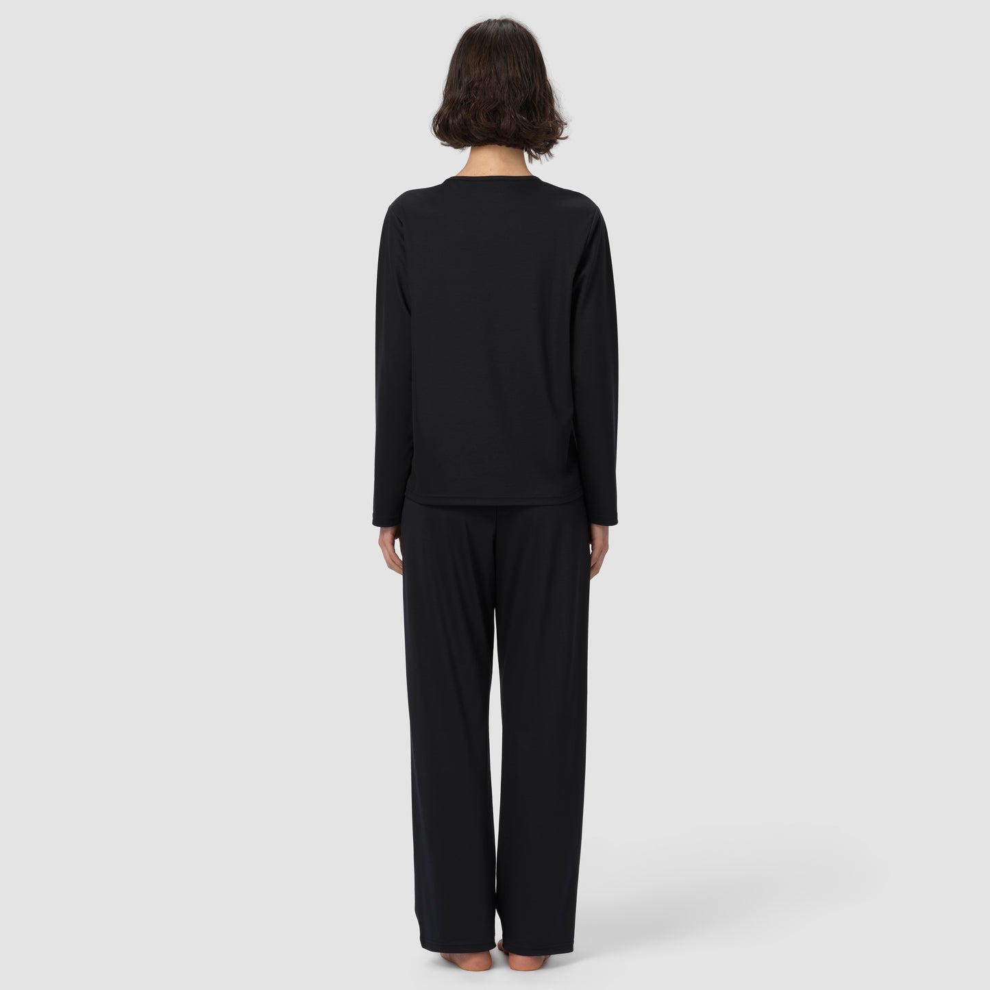 Back of model wearing long black pajama et