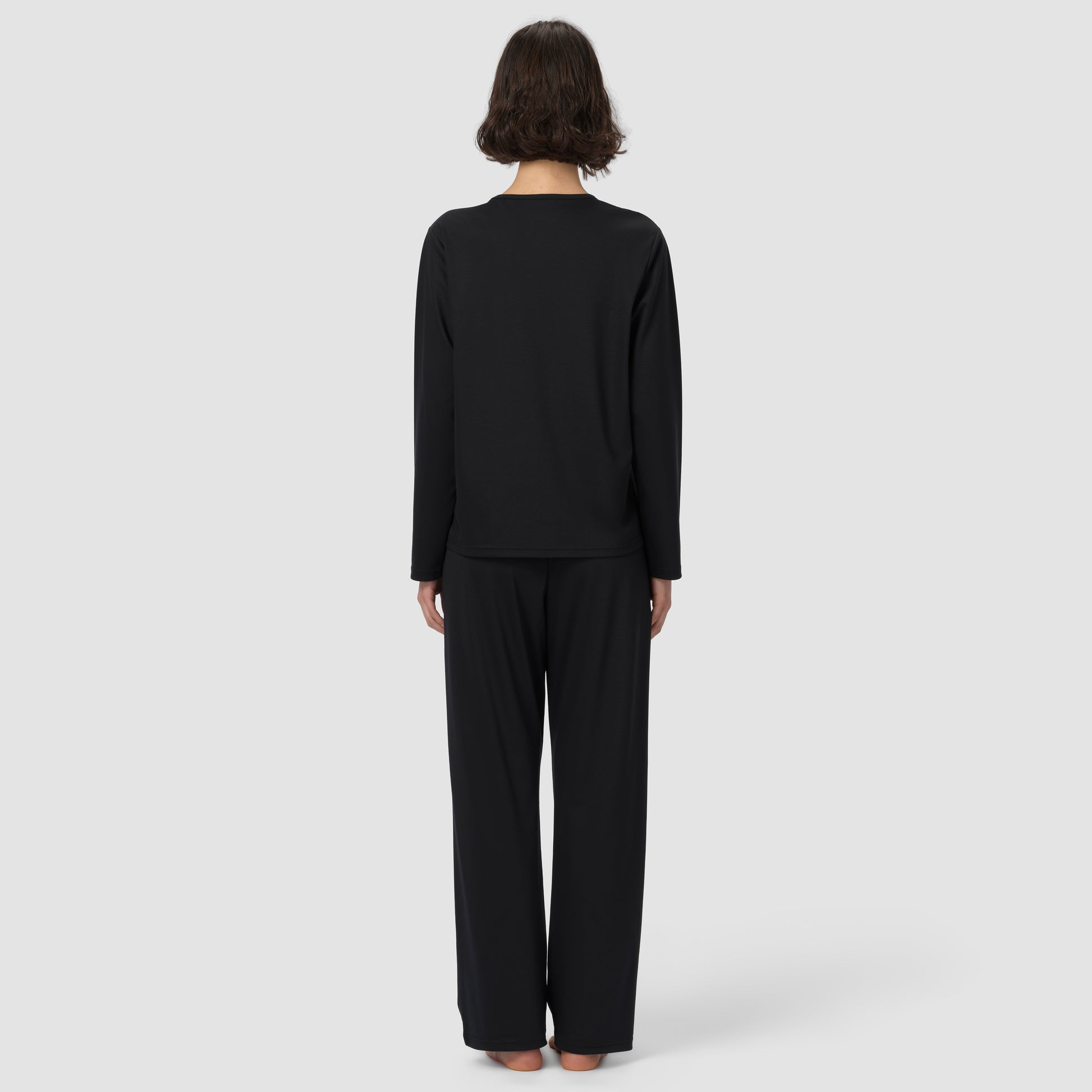 Back of model wearing long black pajama et