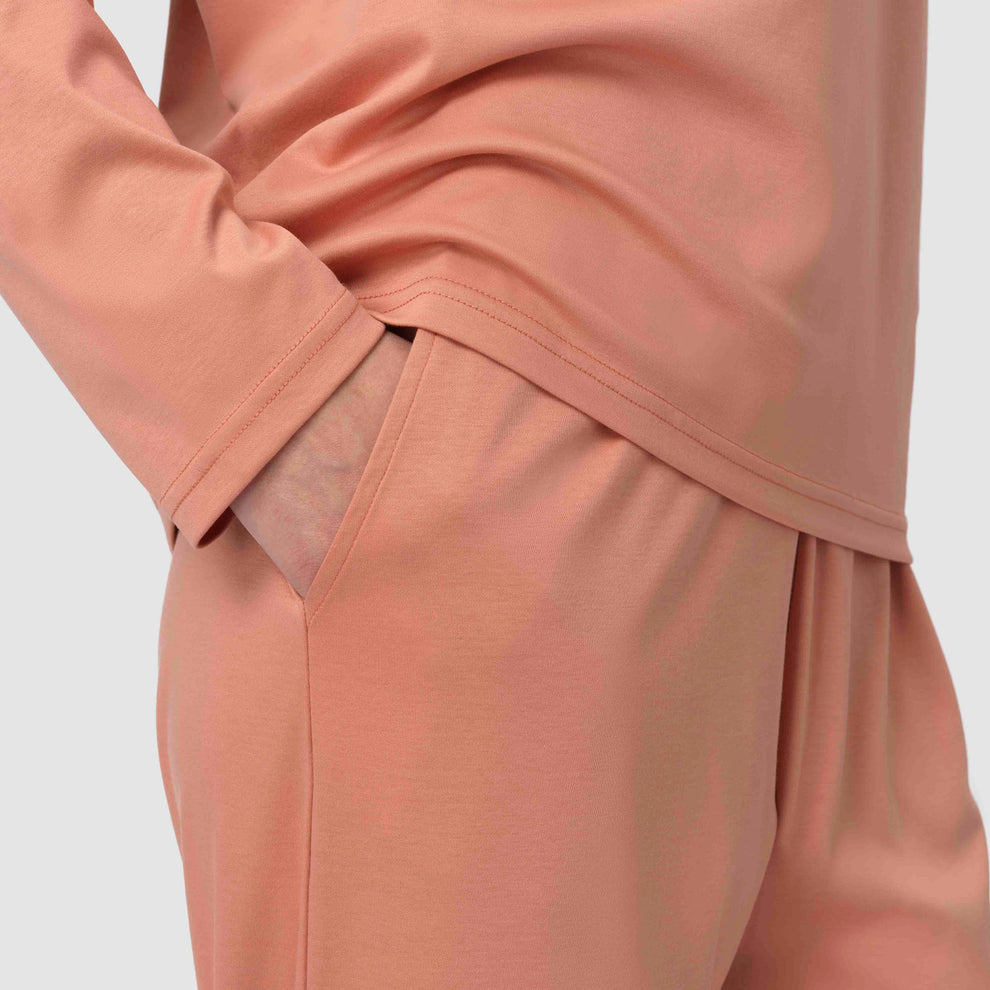 Gros plan sur un pantalon couleur terre cuite, les mains dans les poches