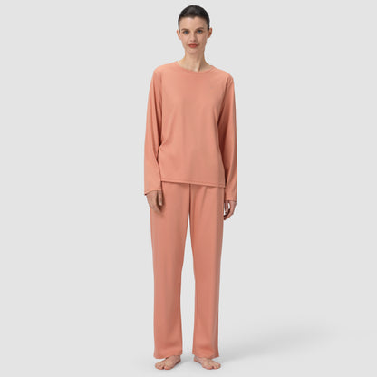 Front of model wearing long pajama set in a terracotta color