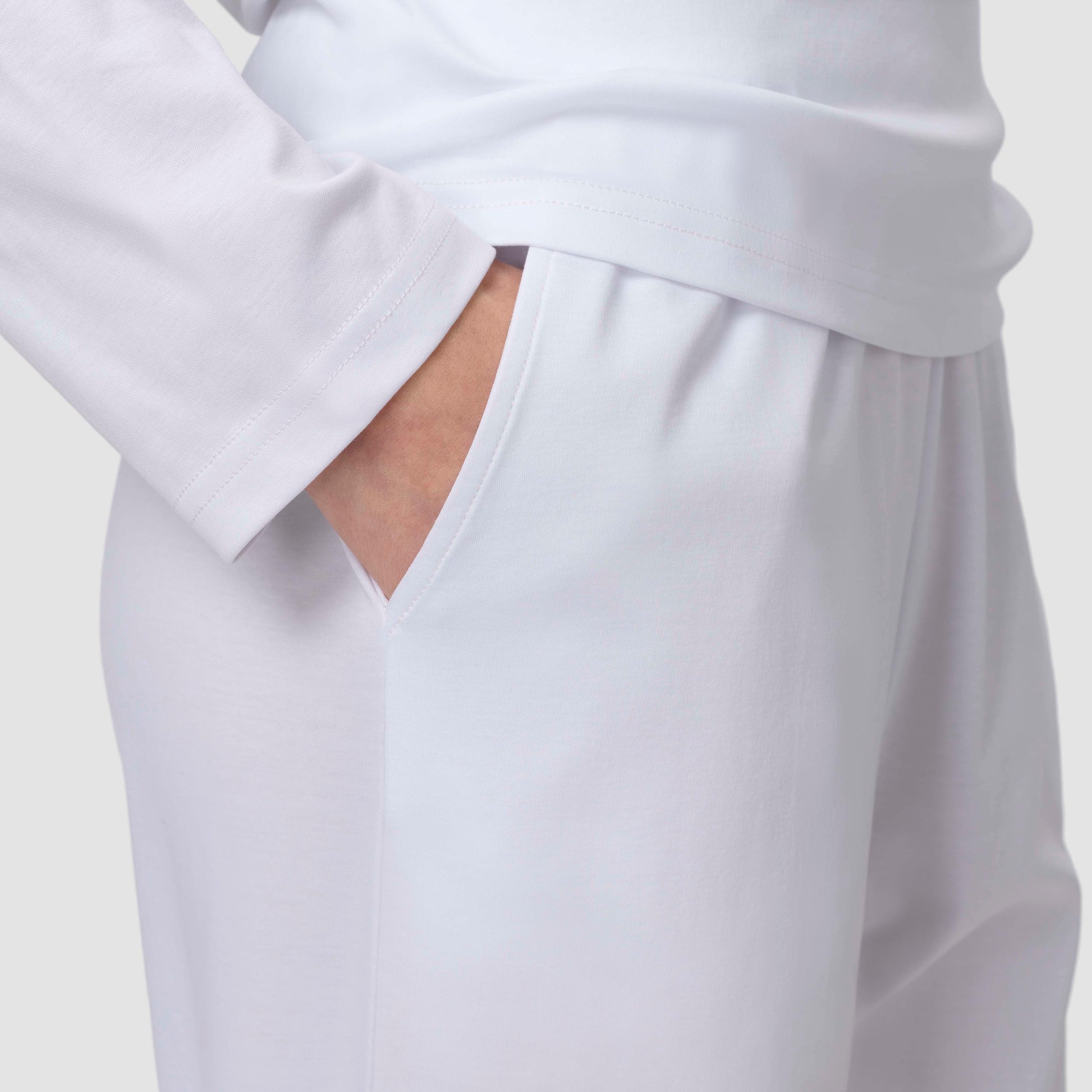 Close up of white pajama pants hand in pocket