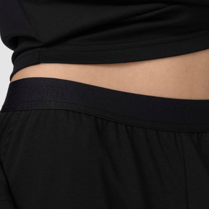 Close-up of black pants with a neutral background
