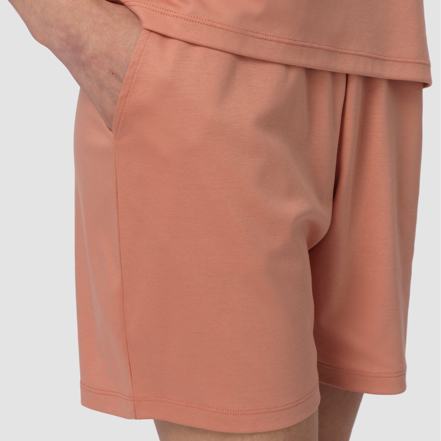 Close-up of peach-colored shorts on a light gray background