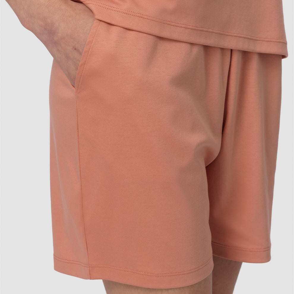 Gros plan sur un short couleur pêche sur fond gris clair