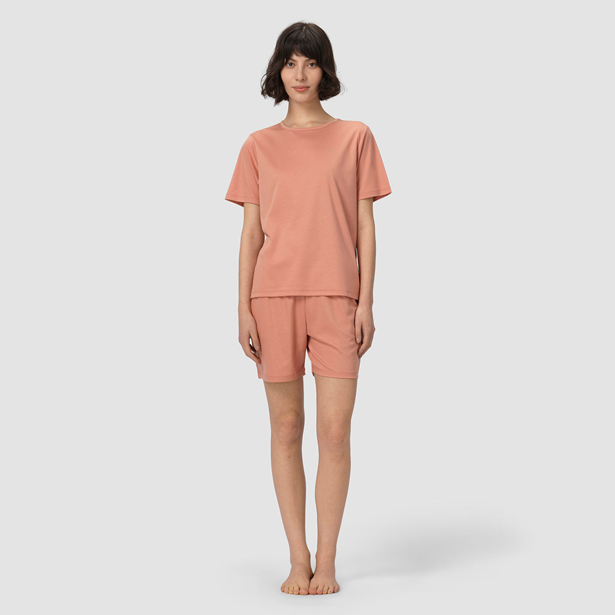 Person wearing a pink pajama set on a white background