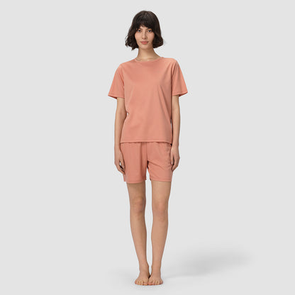 Person wearing a pink pajama set on a white background