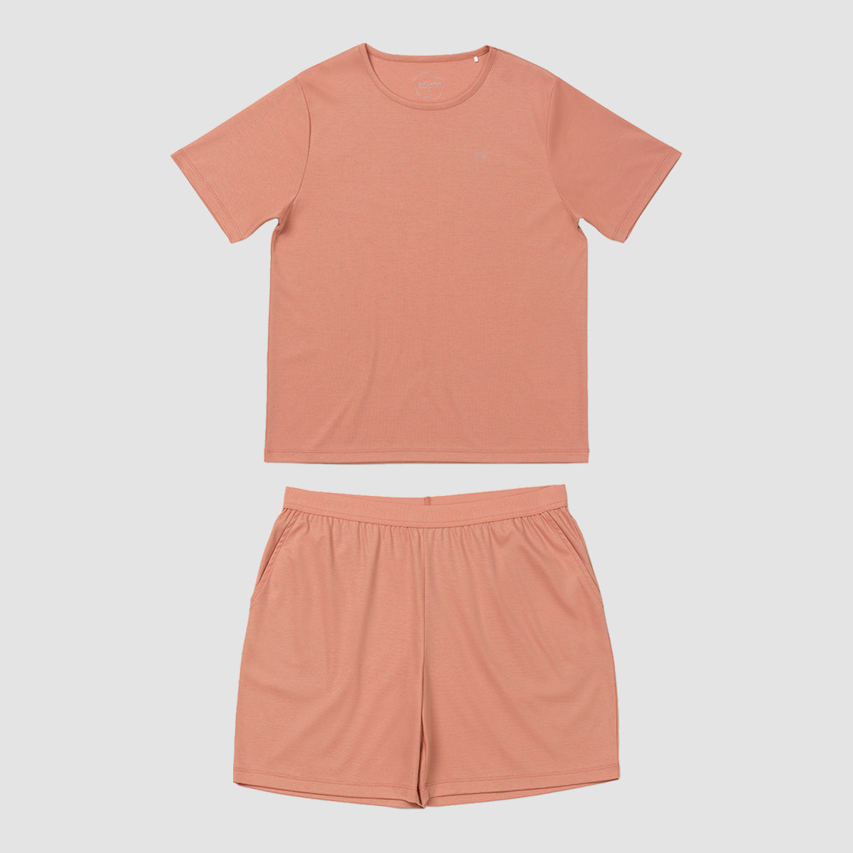 Orangy pink t-shirt and shorts set on a light gray background