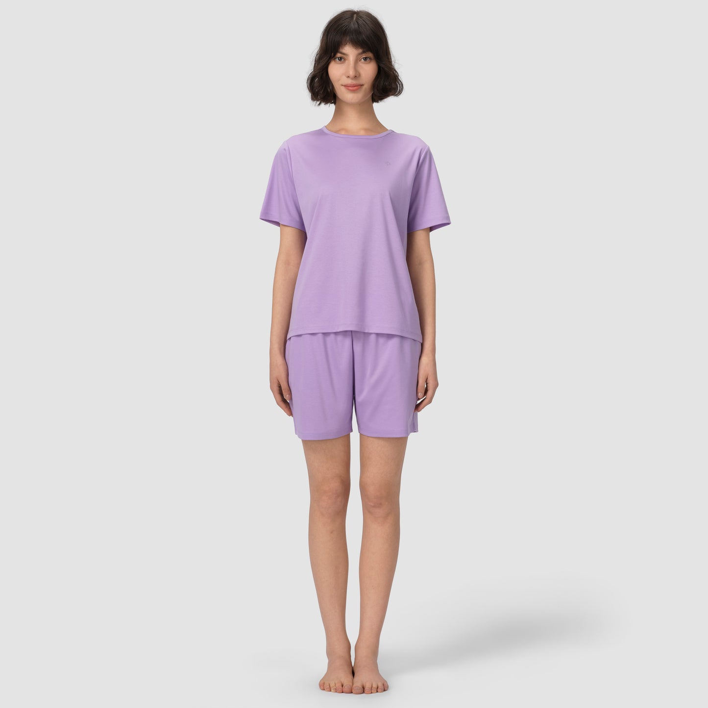 Full feet shot of model wearing lavender pajama set on grey background