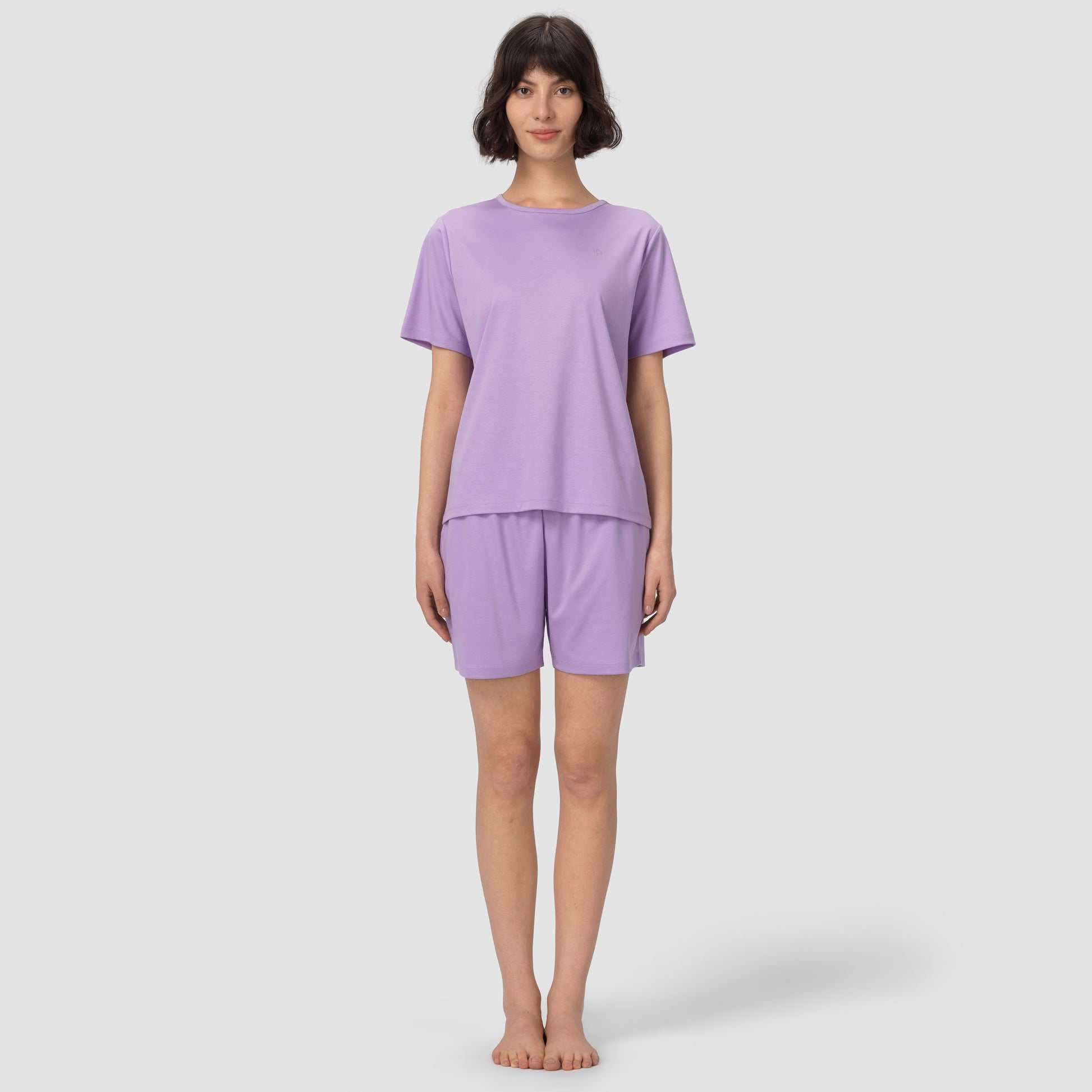 Full feet shot of model wearing lavender pajama set on grey background