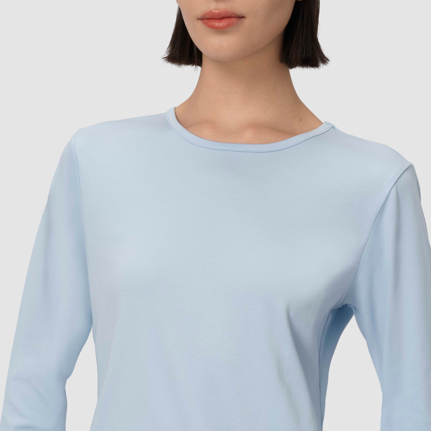 Light blue long-sleeve top worn by a person on a plain background