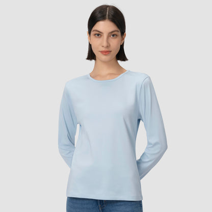 Woman wearing a light blue long-sleeve shirt against a plain background