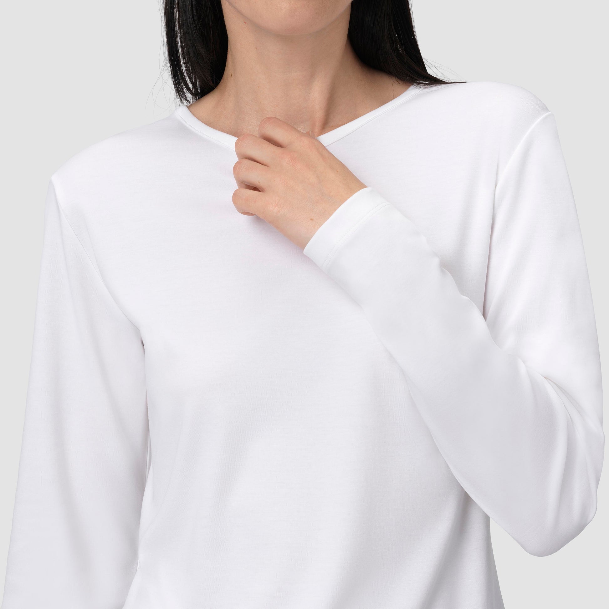 White long-sleeve shirt worn by a person on a plain background