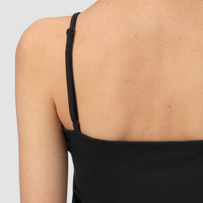 Black spaghetti strap top worn by a person on a light gray background
