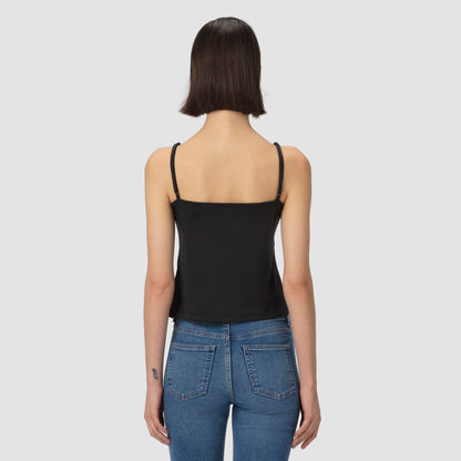 Person wearing a black tank top and blue jeans on a light gray background