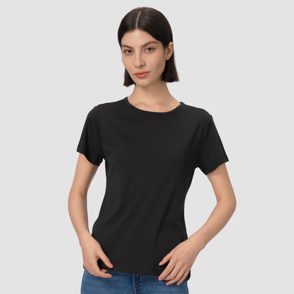 Une personne vêtue d'un t-shirt noir sur un fond uni
