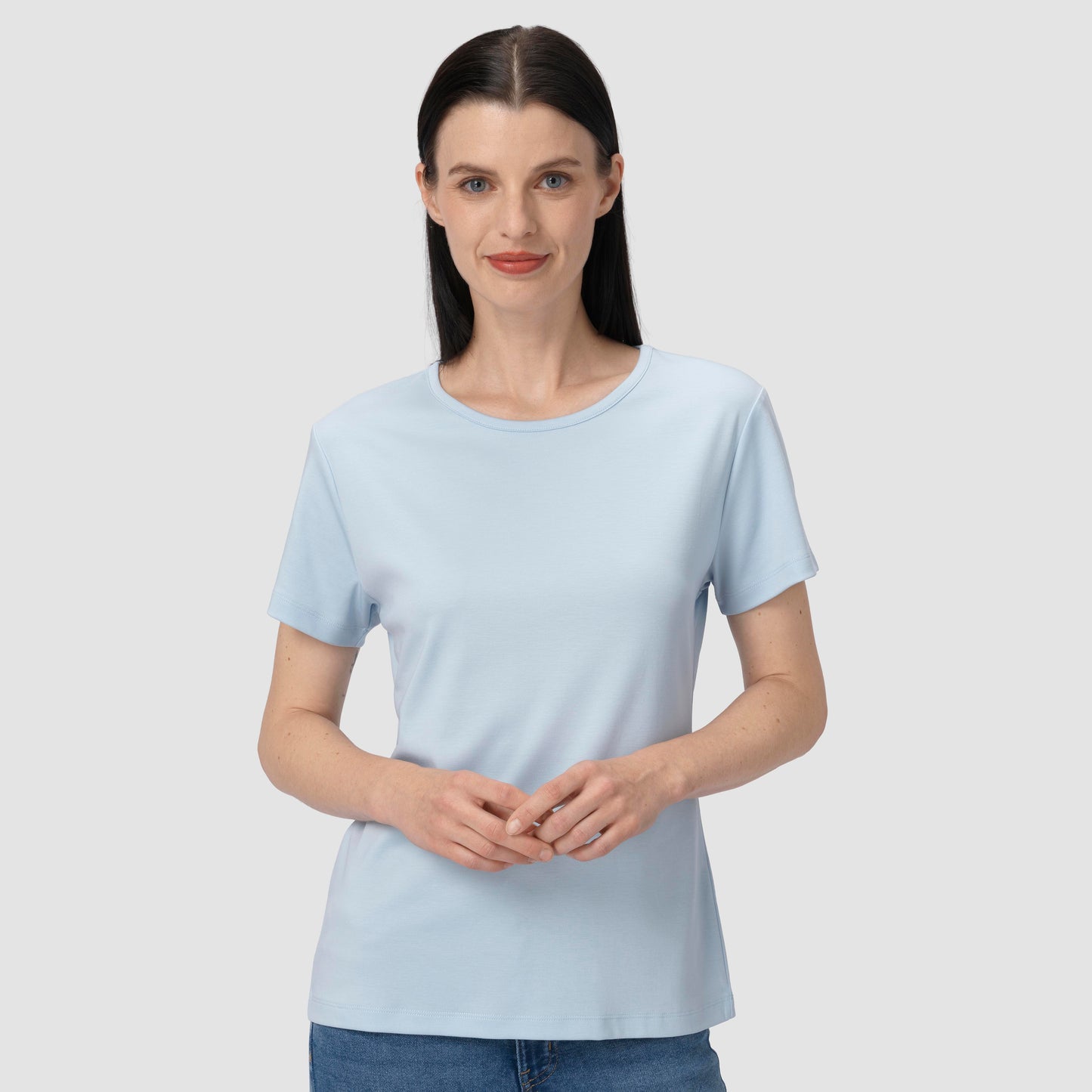 Woman wearing a light blue t-shirt against a plain background
