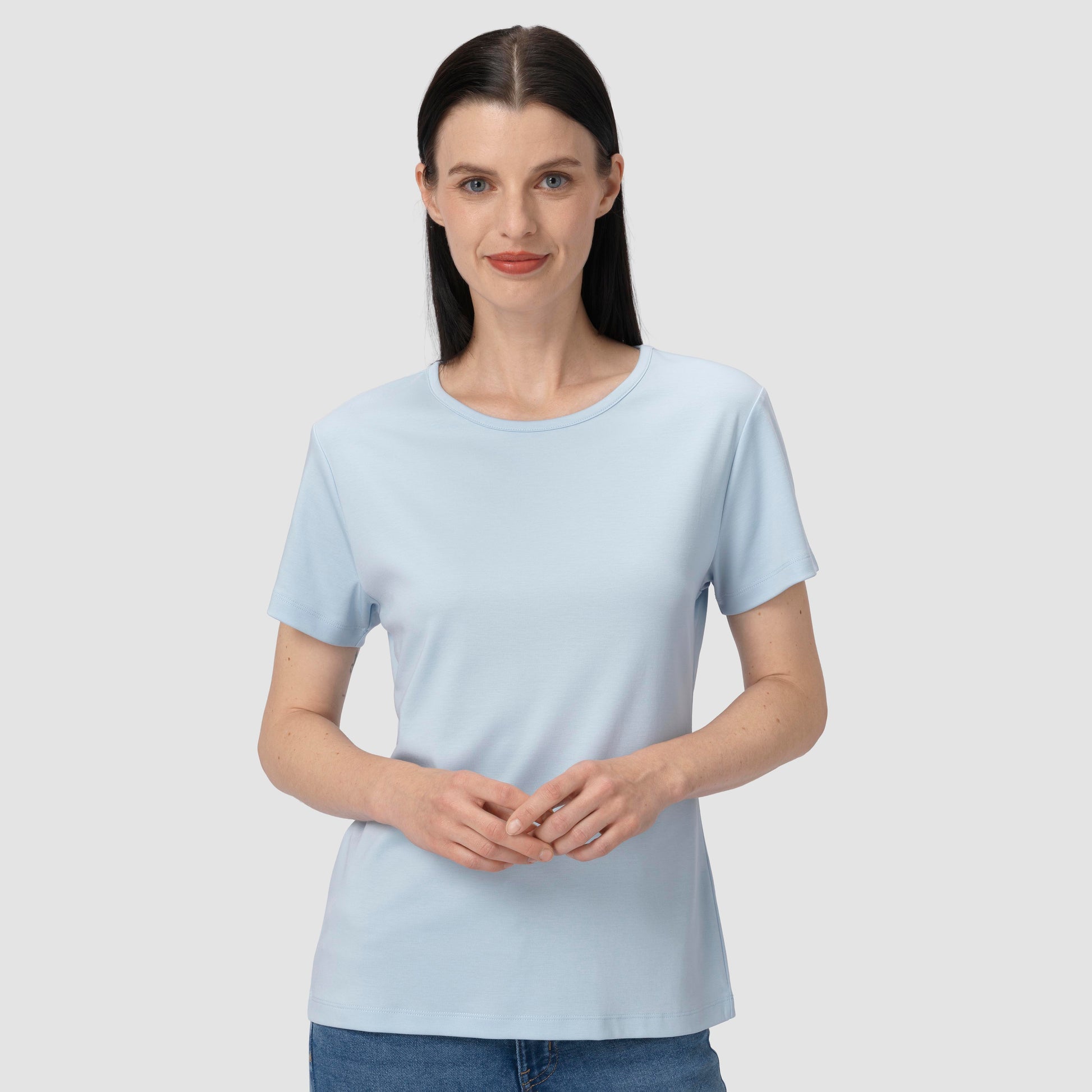 Woman wearing a light blue t-shirt against a plain background