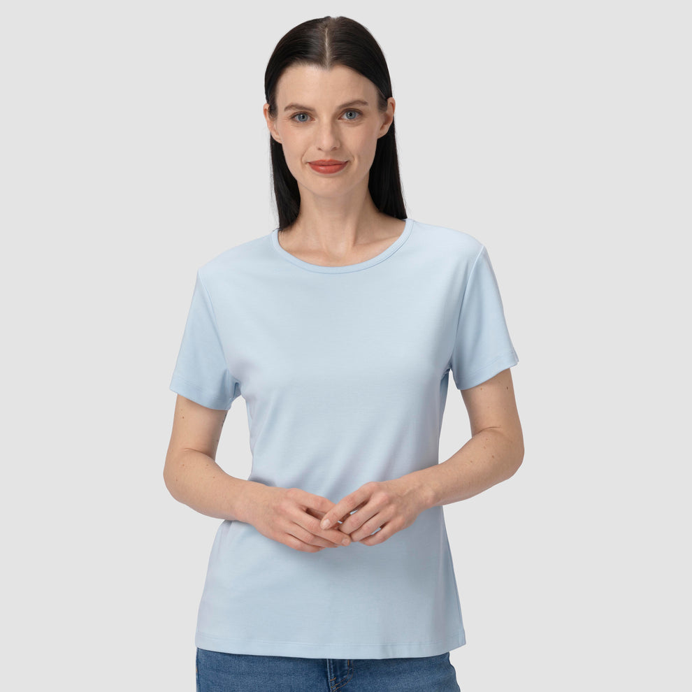 Une femme vêtue d'un t-shirt bleu clair sur un fond uni