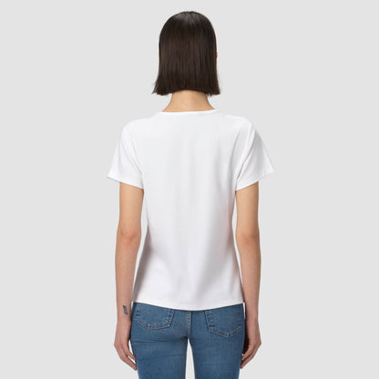 Person wearing a plain white t-shirt and blue jeans on a light gray background