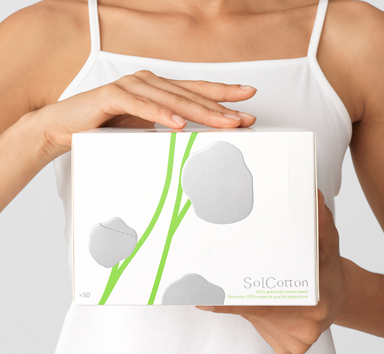 Person holding a XL box of SolCotton cotton towel with a white background